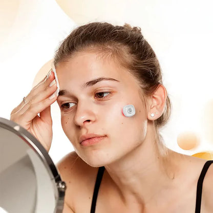 Woman with a Viva Glam Acne LIght Therapy Patch on her face looking into the mirror 