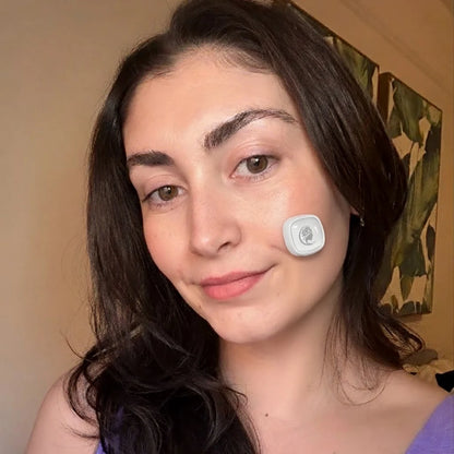 Woman wearing a Viva Glam Acne Light Therapy patch on her neck with a neutral background